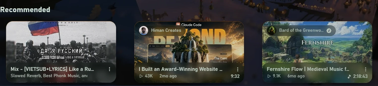 A row of three recommended videos as rounded cards. There is no Shorts shelf.